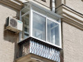 Холодное остекление балкона алюминиевыми окнами с металлической крышей Москве