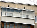 Холодное остекление балкона  алюминиевыми окнами с отделкой стен вагонкой ПВХ и с кровлей из профлиста